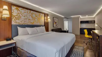 a hotel room with a large bed and a kitchen at The Hub Murray Hill, BW Premier Collection in New Providence