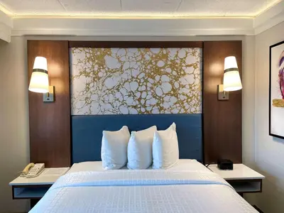 a hotel room with a bed with white pillows at The Hub Murray Hill, BW Premier Collection in New Providence