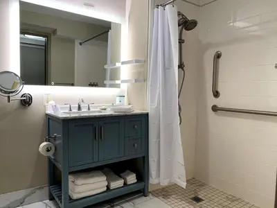 a bathroom with a blue sink and a shower at The Hub Murray Hill, BW Premier Collection in New Providence