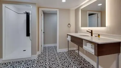 a bathroom with a sink and a mirror at The Hub Murray Hill, BW Premier Collection in New Providence