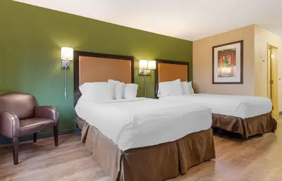 a hotel room with two beds and a chair at Extended Stay America Suites - Philadelphia - Mt Laurel - Crawford Place in Mount Laurel