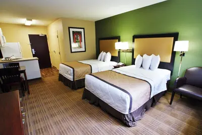 a hotel room with two beds and a chair at Extended Stay America Suites - Philadelphia - Mt Laurel - Crawford Place in Mount Laurel