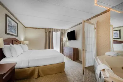 a hotel room with a large bed and a tub at Best Western Plus Wilkes Barre Center City in Wilkes-Barre