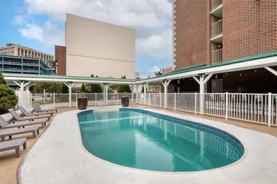 a swimming pool with chairs and a building at Best Western Plus Wilkes Barre Center City in Wilkes-Barre
