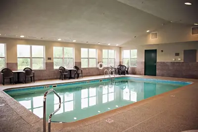 a large swimming pool with chairs and a table at Country Inn & Suites by Radisson, Frackville (Pottsville), PA in Mount Pleasant