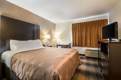 a hotel room with a bed and a flat screen tv at Quality Inn Bloomsburg in Bloomsburg
