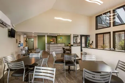 a restaurant with wooden tables and chairs and windows at Quality Inn Bloomsburg in Bloomsburg