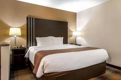 a large bed in a hotel room with two lamps at Quality Inn Bloomsburg in Bloomsburg