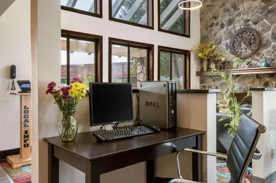 a desk with a computer and flowers on it at Quality Inn Bloomsburg in Bloomsburg