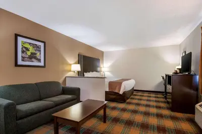 a hotel room with a couch and a bed at Quality Inn Bloomsburg in Bloomsburg