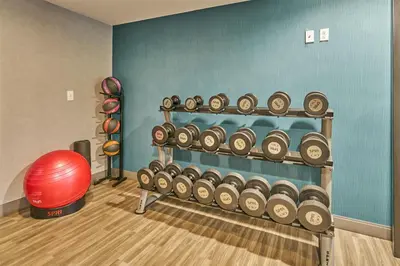 a gym with a rack of dumbbells and a red ball at Hampton Inn Flemington in Flemington