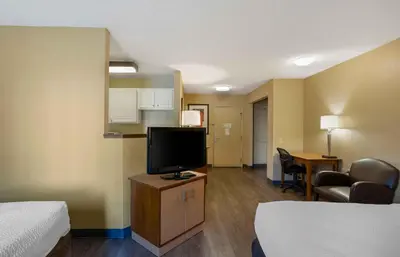 a hotel room with a tv and a bed and a desk at Extended Stay America Suites - Philadelphia - Airport - Bartram Ave in Philadelphia