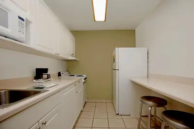a kitchen with white cabinets and a white refrigerator at Extended Stay America Suites - Philadelphia - Airport - Bartram Ave in Philadelphia