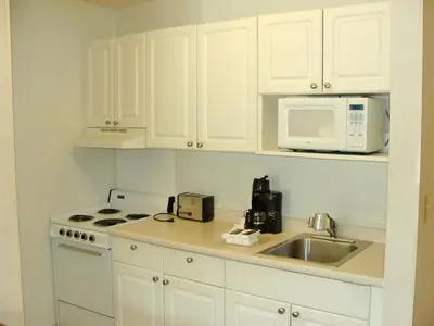 a kitchen with white cabinets and a sink and a microwave at Extended Stay America Suites - Philadelphia - Airport - Bartram Ave in Philadelphia