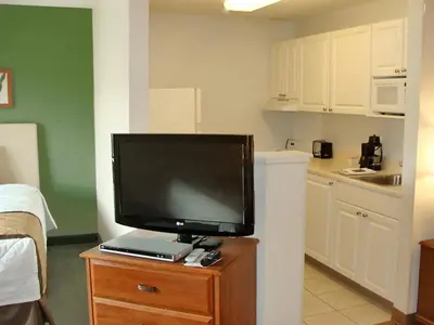 a flat screen tv sitting on top of a wooden dresser at Extended Stay America Suites - Philadelphia - Airport - Bartram Ave in Philadelphia