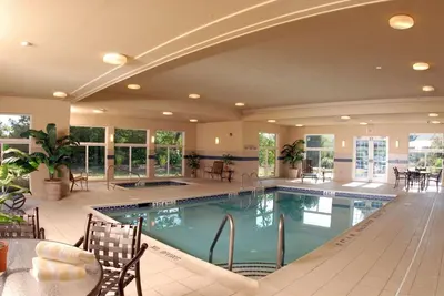 a large swimming pool with tables and chairs in a building at Country Inn & Suites by Radisson, Lewisburg, PA in Lewisburg