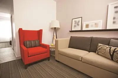 a living room with a couch and a red chair at Country Inn & Suites by Radisson, Lewisburg, PA in Lewisburg