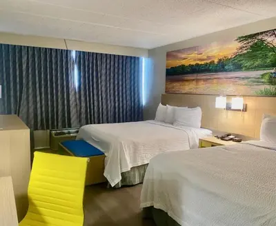 a hotel room with two beds and a yellow chair at Days Inn by Wyndham Scranton PA in Dickson City