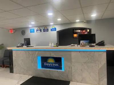 a reception desk with a drexim sign on a counter at Days Inn by Wyndham Scranton PA in Dickson City