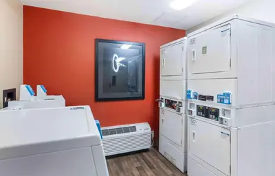 a kitchen with white appliances and an orange wall at Extended Stay America Suites - Philadelphia - Mt Laurel - Pacilli Place in Mount Laurel