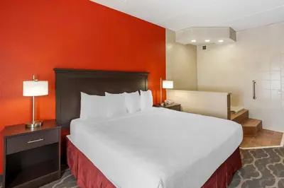 a large bed in a hotel room with orange walls at Best Western Inn at Blakeslee-Pocono in Blakeslee