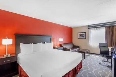 a hotel room with a large bed and a chair at Best Western Inn at Blakeslee-Pocono in Blakeslee