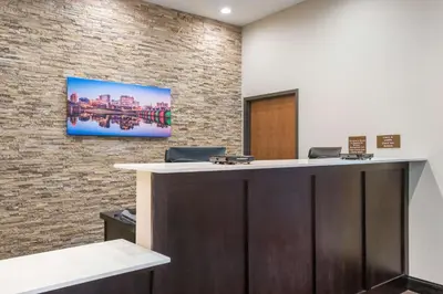 an office with a reception desk and a brick wall at Comfort Inn & Suites Harrisburg - Hershey West in Harrisburg