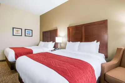 a hotel room with two beds and a chair at Comfort Inn & Suites Harrisburg - Hershey West in Harrisburg