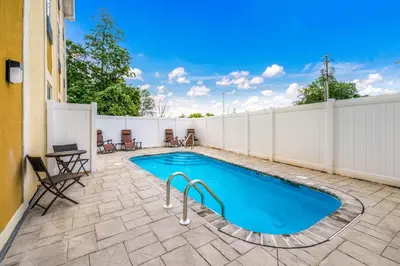 a swimming pool on a patio with a fence at Comfort Inn & Suites Harrisburg - Hershey West in Harrisburg
