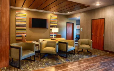 a room with a table and chairs and a television at Holiday Inn Express Bordentown - Trenton South by IHG in Bordentown