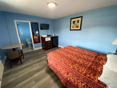 a hotel room with a bed and a table and a desk at Red Carpet Inn & Suites Wrightstown in Wrightstown