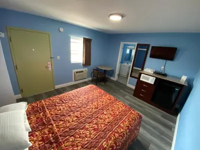 a hotel room with a bed and a television at Red Carpet Inn & Suites Wrightstown in Wrightstown