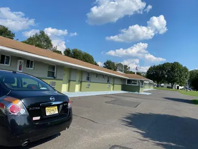 a black car parked in front of a building at Red Carpet Inn & Suites Wrightstown in Wrightstown