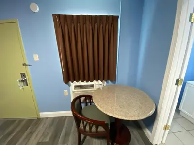 a small table and chairs in a room with a window at Red Carpet Inn & Suites Wrightstown in Wrightstown