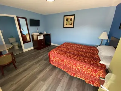 a hotel room with a bed and a table at Red Carpet Inn & Suites Wrightstown in Wrightstown