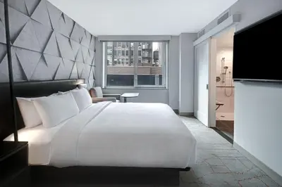 a bedroom with a large white bed and a television at SpringHill Suites by Marriott New York Midtown Manhattan/Park Ave in New York