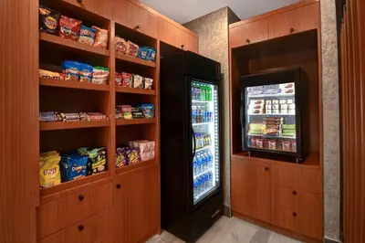 a kitchen with a refrigerator and a television at SpringHill Suites by Marriott New York Midtown Manhattan/Park Ave in New York