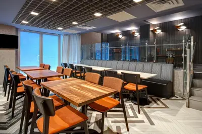 a dining room with wooden tables and chairs at SpringHill Suites by Marriott New York Midtown Manhattan/Park Ave in New York