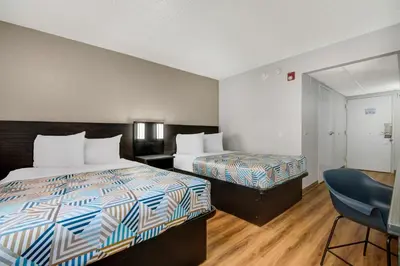 a hotel room with two beds and a chair at Motel 6-York, PA - North in York
