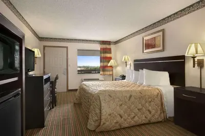 a hotel room with a bed and a flat screen tv at Days Inn by Wyndham Grantville in Grantville