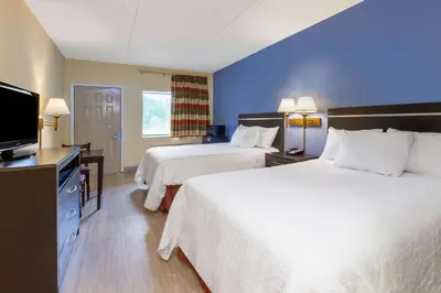 a hotel room with two beds and a flat screen tv at Days Inn by Wyndham Grantville in Grantville