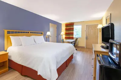 a hotel room with a bed and a flat screen tv at Days Inn by Wyndham Grantville in Grantville