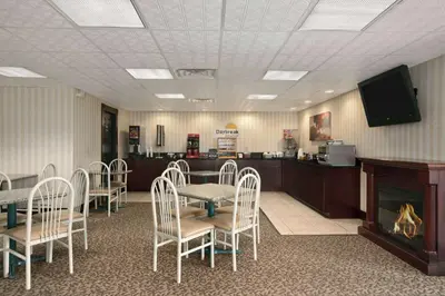 a waiting room with a table and chairs and a fireplace at Days Inn by Wyndham Grantville in Grantville