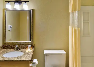a bathroom with a sink and a toilet and a mirror at Windsor Hotel in East Windsor