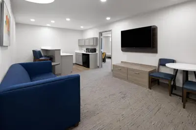 a waiting room with a blue couch and a tv at Holiday Inn Express & Suites Wyomissing by IHG in West Reading