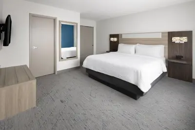 a hotel room with a large bed and a television at Holiday Inn Express & Suites Wyomissing by IHG in West Reading