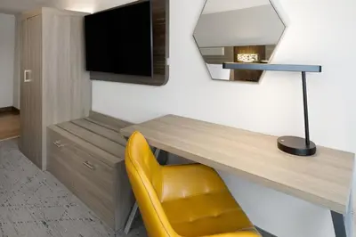a desk with a yellow chair in a room at Holiday Inn Express & Suites Wyomissing by IHG in West Reading