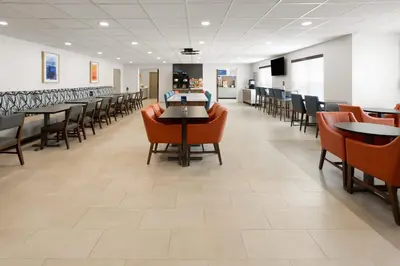 a waiting room with tables and chairs in a hospital at Holiday Inn Express & Suites Wyomissing by IHG in West Reading