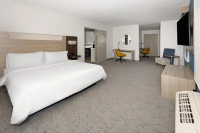 a hotel room with a large white bed and a desk at Holiday Inn Express & Suites Wyomissing by IHG in West Reading