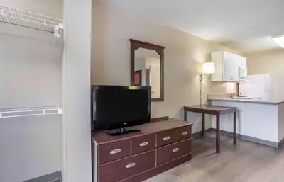 a hotel room with a television on a dresser with a kitchen at Extended Stay America Suites - Somerset - Franklin in Somerset
